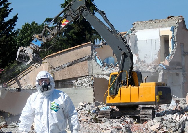 Diagnostic amiante avant travaux : opérateur en combinaison et masque sur un chantier